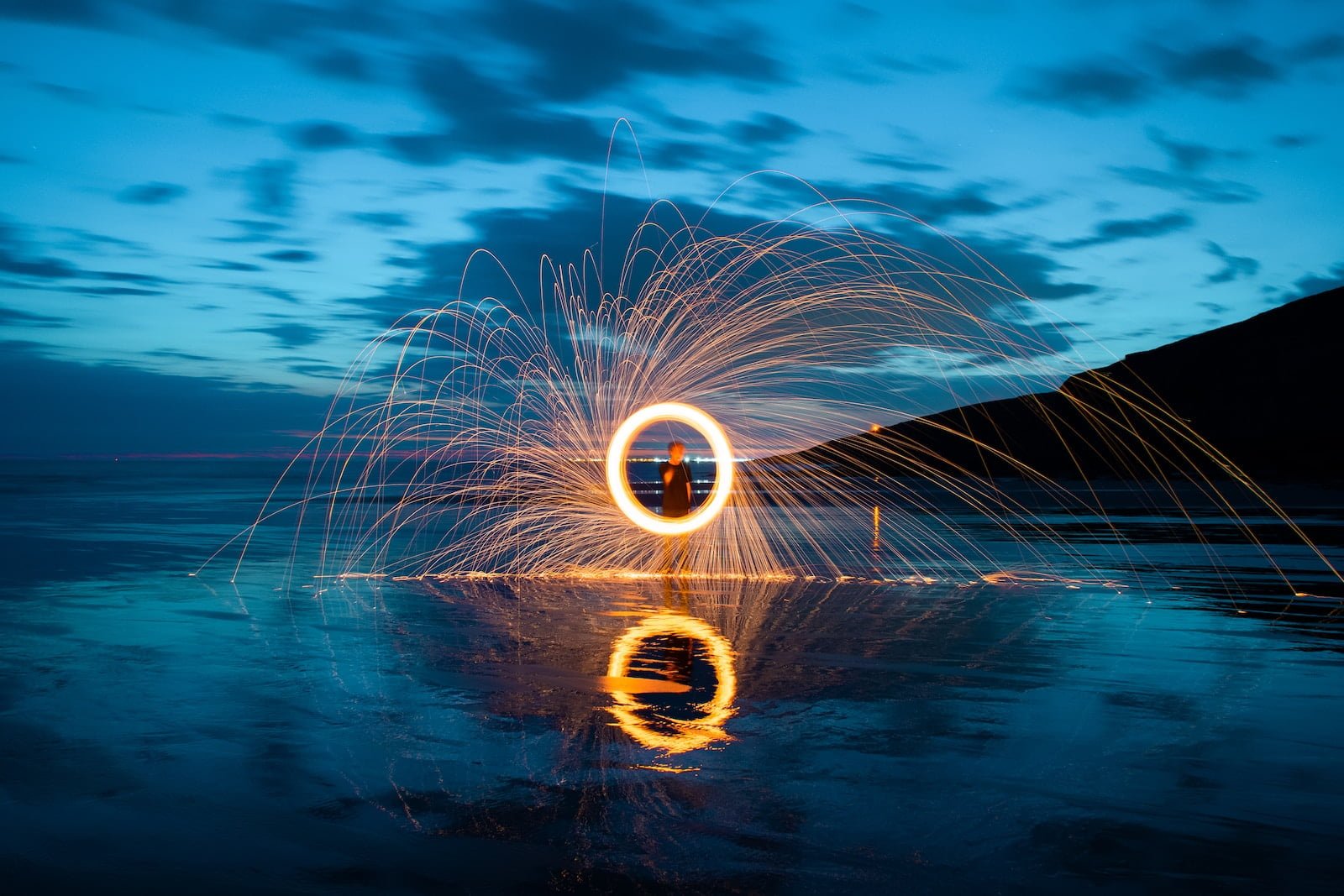 person in front of fire ring during nighttime